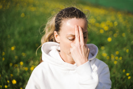 Woman keeping her eyes closed and doing breathing exerciseの写真素材