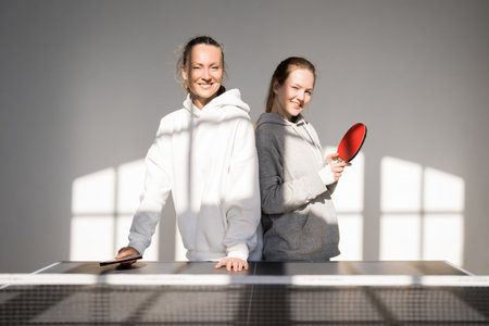 Mother and daughter preparing to playing tennis table at homeの写真素材