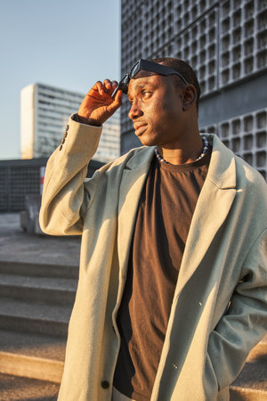 Vertical view of fashionable multiracial man in trendy clothes looking awayの写真素材