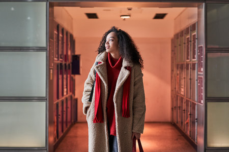 Young multiracial girl looking away and walking from the locker room at the airportの写真素材