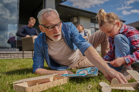 Little cute girl enjoying game and spending time with her grandfather while playingの写真素材