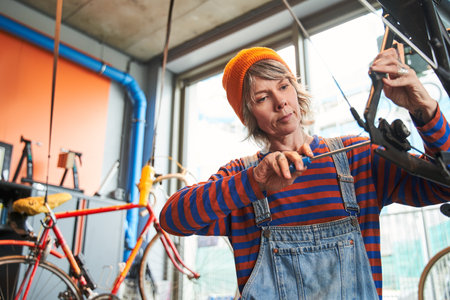 Young woman fixing modern cycle transmission systemの写真素材