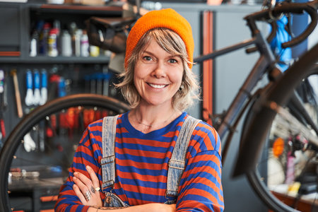 Joyful bike repair specialist crossing arms and looking at the camera while posingの写真素材