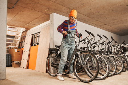 Full length view of the focused woman checking bike while preparing repairing itの写真素材