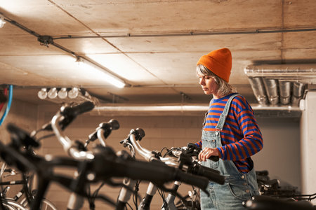 Waist up portrait view of the bike store worker taking bicycle while preparing it for the sellingの写真素材
