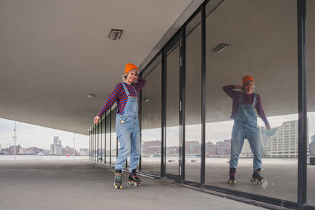 Full body portrait of active funky woman learning to ride on roller skatesの写真素材