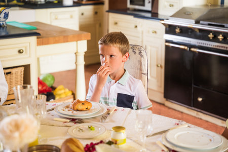 Concentrated child looking away while spending time together with relativesの写真素材