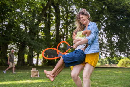 Happy mother and her son relaxing and embracing on the grass in a summer meadowの写真素材