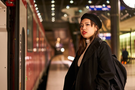 Beautiful multiracial woman looking away while standing at terminal train station
