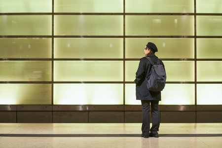 Young asian woman with brunette hair wearing black hat standing at the metro stationの写真素材