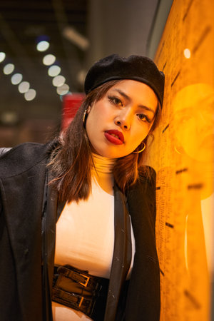 Vertical view of the teen girl in stylish clothes standing tunnel with neon light wallsの写真素材