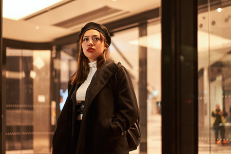 Beautiful multiracial woman looking away while standing at terminal train stationの写真素材
