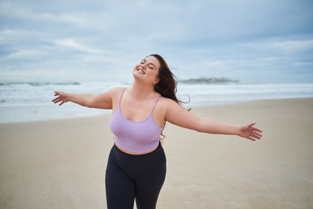 Happy pleasant woman spread her arms and enjoying sea breezeの写真素材