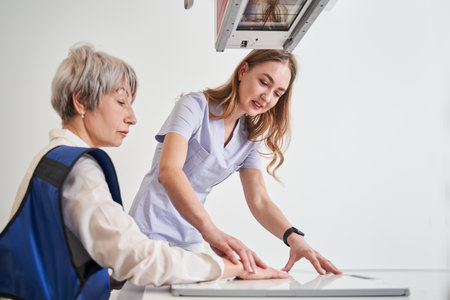 Woman GP or therapist making x ray to unhealthy mature female patient in clinicの写真素材