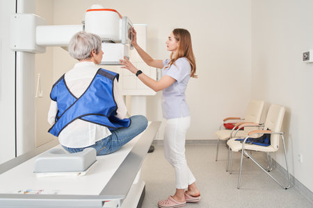 Female physician turning x ray machine for making check up for senior ladyの写真素材