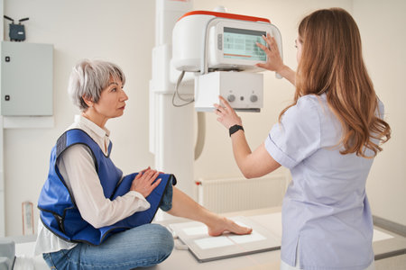 Back view of the nurse woman preparing to scanning woman patient hand on modern X-rayの写真素材