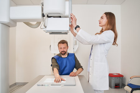 Nurse woman preparing to scanning man patient hand on X-ray scannerの写真素材