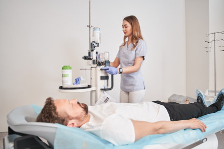 Lady doctor and male patient preparing for tomography in chamberの写真素材