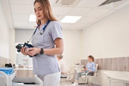 Young female nurse doctor preparing measure high low blood pressureの写真素材