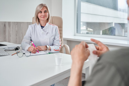 Smiling woman psychologist talking with her patient with pleasure smileの写真素材