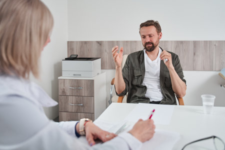 Psychotherapist working with young depressed man at the sessionの写真素材