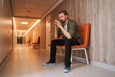 Sad man patient nervously impatiently waiting in the hospital lobbyの写真素材