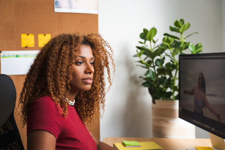 African american curly woman staring at computer screen and feeling focusedの写真素材