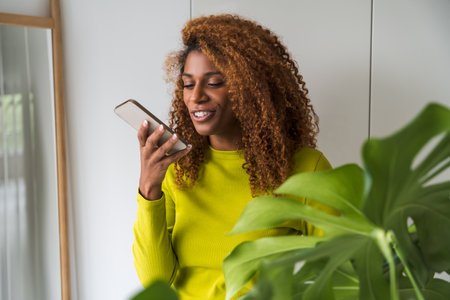 Waist up portrait view of the african american woman recording voice messageの写真素材