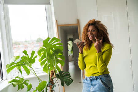 African american happy woman video calling mobile phoneの写真素材