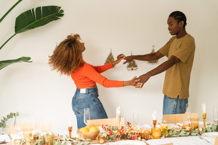 Romantic african american pair holding hands and dancing near the New Yearの写真素材