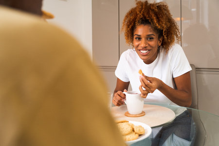 Portrait of smiling loving couple having breakfast while sitting at the tableの写真素材