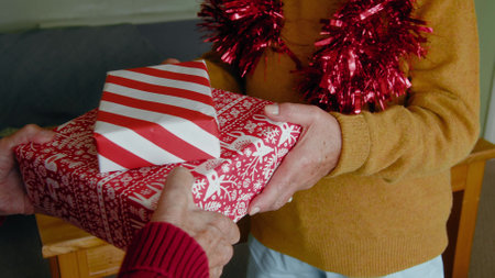 Cropped view of senior man hands giving present to loving wife