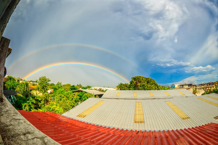 rainbows on blue sky over the roof topの写真素材