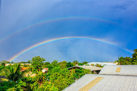 rainbows on blue sky over the roof topの写真素材