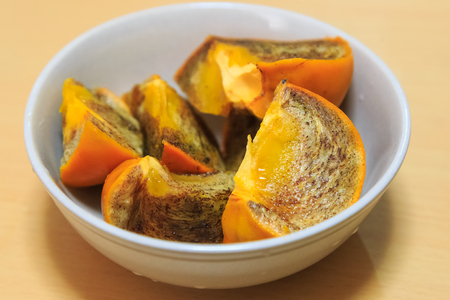 Persimmon in white ceramic blowの写真素材
