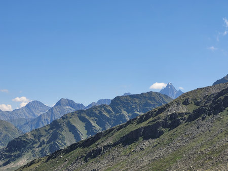 Mountain landscape with snow-capped peaks under the blue skyの写真素材