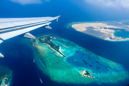 Aerial view of tropical islands and atolls in the Maldives from a plane windowの写真素材