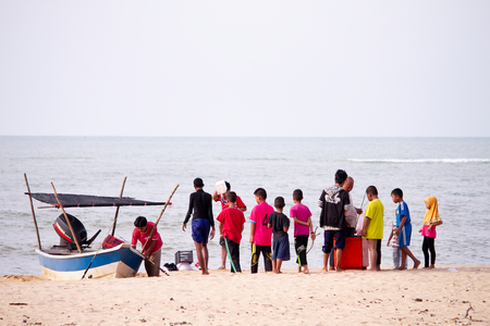 Children and fisherman on the beachのeditorial素材