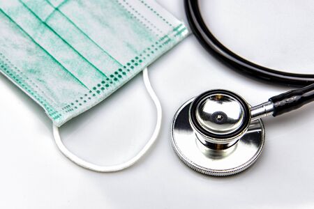 Closed up Stethoscope and Blue Surgical Mask on White Background