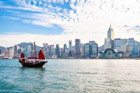 Hong Kong - December 18, 2019 : Duk Ling Tourist Junk Ship cruising in Victoria Harbour with Skyscraper Buildings of Hong Kong Background, Hong Kongのeditorial素材