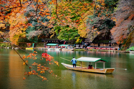 Japan -November 21, 2019 : Japanese Boatman punting Katsura Tourist sightseeing boat along Katsura River in autumn, Arashiyama, Kyotoのeditorial素材