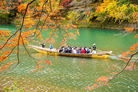 Japan - November 19, 2019 : Tourists enjoy sightseeing scenic view of colorful maple trees along Katsura river in autumn , Arashiyama, Kyotoのeditorial素材