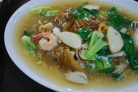 Fried wide rice noodle in gravy with mix seafood and vegetablesの写真素材