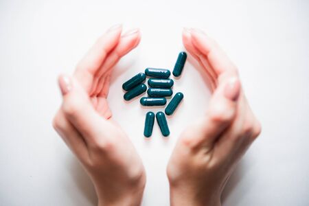 Pills in hands on a white background.