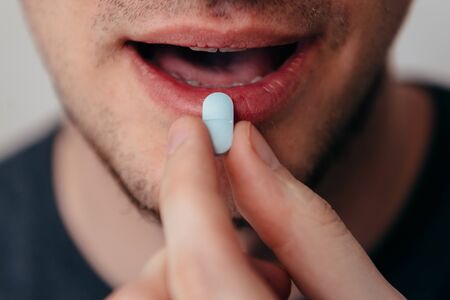 Man puts a blu pill in her mouth.