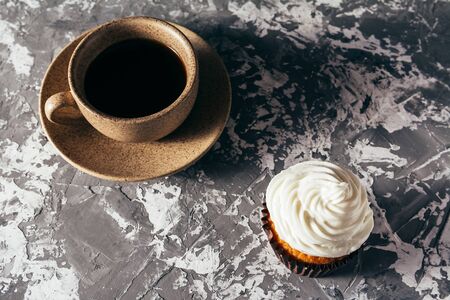 Cupcakes with cups of coffee on a gray backgroundの写真素材