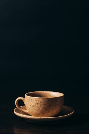 Cup with black coffee on a black background.