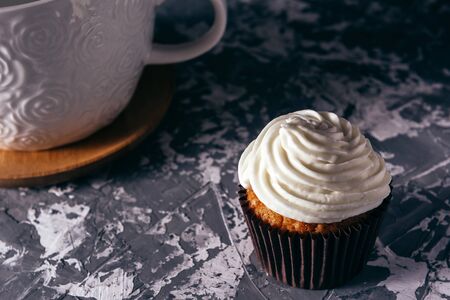 Cupcakes with cups of coffee on a gray backgroundの写真素材