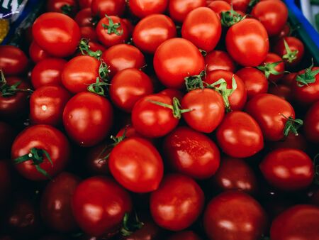 Lot of red tomatoes in a blue box photographed close.の写真素材