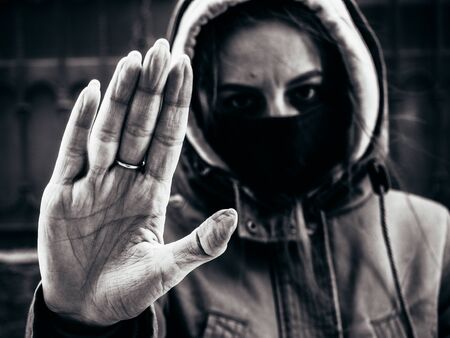 Black-white photograph of a hand in wrinkles of the feet of a coronavirus.の写真素材